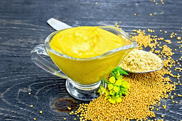 Image showing Sauce mustard in sauceboat with powder and flower on board