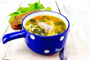 Image showing Soup with couscous and spinach in blue bowl on napkin