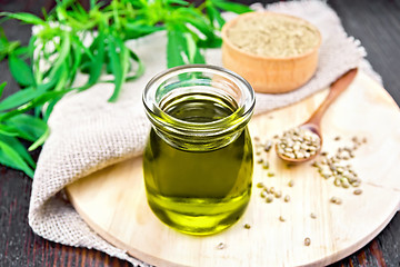 Image showing Oil hemp in jar with burlap on dark board