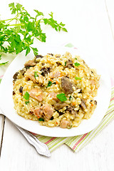 Image showing Risotto with mushrooms and chicken on wooden board