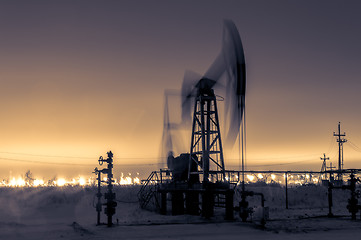 Image showing Pump jack and refinery at night.