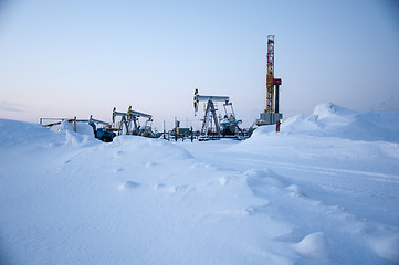 Image showing Oil field. Drilling rig and oil pump.