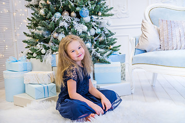 Image showing Cute girl sitting near Christmas Tree