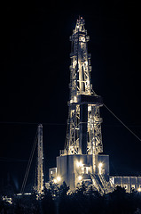 Image showing Oil field. Drilling rig at night.