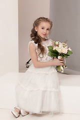 Image showing Little pretty girl with flowers dressed in wedding dresses