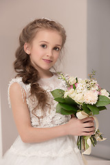 Image showing Little pretty girl with flowers dressed in wedding dresses