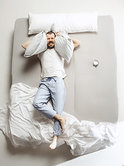 Image showing Top view photo of young man sleeping in a big white bed