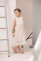 Image showing Little pretty girl with flowers dressed in wedding dresses