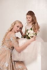 Image showing Little pretty girls with flowers dressed in wedding dresses