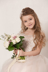 Image showing Little pretty girl with flowers dressed in wedding dresses