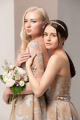 Image showing Brides in beautiful dress standing indoors in white studio interior like at home. Trendy wedding style shot. Young attractive caucasian model like a bride tender looking.