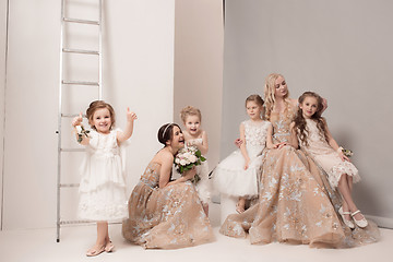 Image showing Little pretty girls with flowers dressed in wedding dresses