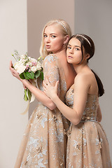 Image showing Brides in beautiful dress standing indoors in white studio interior like at home. Trendy wedding style shot. Young attractive caucasian model like a bride tender looking.