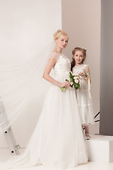 Image showing Little pretty girls with flowers dressed in wedding dresses