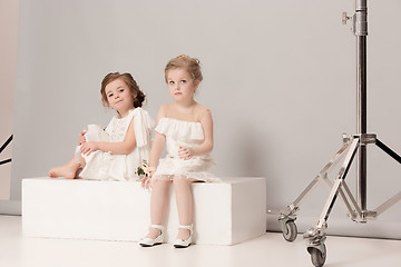 Image showing Little pretty girls with flowers dressed in wedding dresses