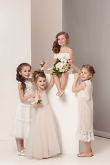 Image showing Little pretty girls with flowers dressed in wedding dresses