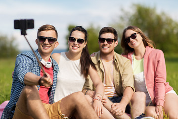 Image showing friends taking picture by selfie stick in summer