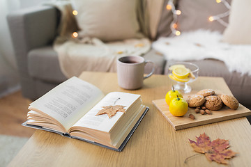 Image showing book, lemon, tea and cookies on table at home