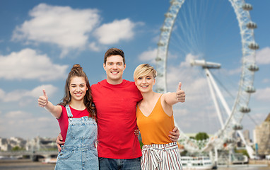 Image showing happy friends showing thumbs up over ferry wheel