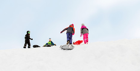 Image showing kids with sleds climbing snow hill in winter