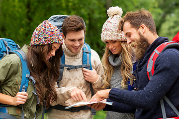 Image showing friends or travelers hiking with backpacks and map