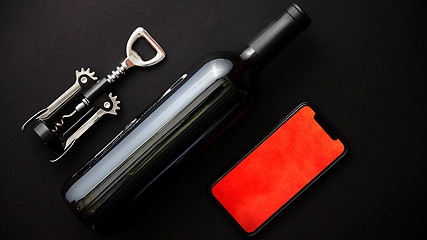 Image showing Red wine bottle, corkscrew and boxed christmas gift