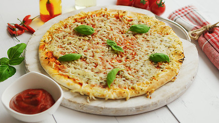 Image showing Delicious italian pizza served on wooden table, shot from side