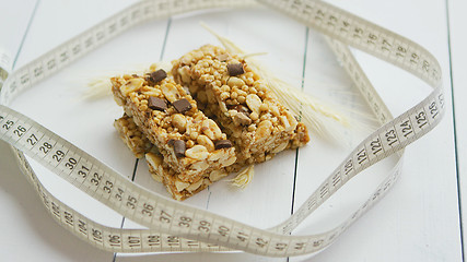 Image showing Granola bars with dried fruits wooden background