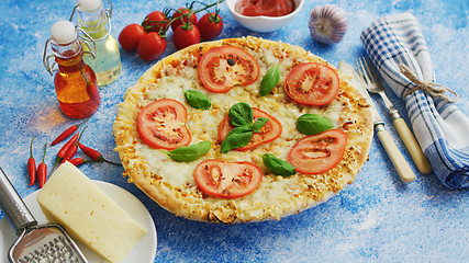 Image showing Delicious italian pizza served on blue stone table, shot from side