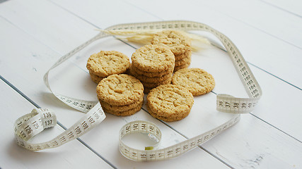 Image showing Healthy oatmeal cookies on white wood background, side view.