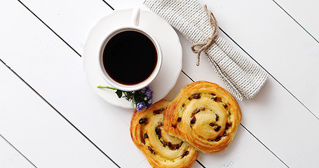 Image showing Delicious pastry with raisins and a cup of coffee top view.