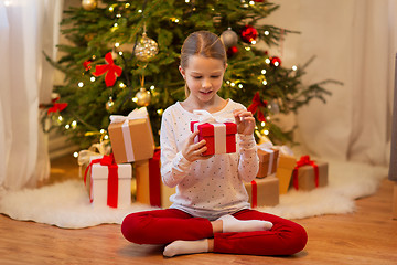 Image showing smiling girl with christmas gift at home