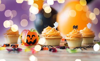 Image showing halloween party decorated cupcakes on wooden table