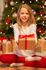 Image showing smiling girl with christmas gift at home