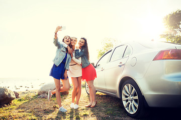 Image showing happy women taking selfie near car at seaside