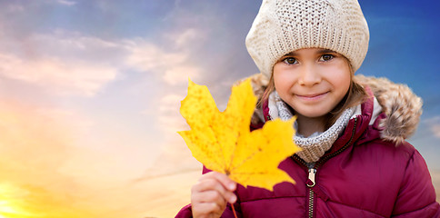 Image showing close up of girl with maple leaf in autumn