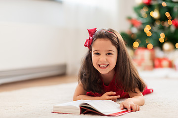 Image showing happy girl reading book at home on christmas