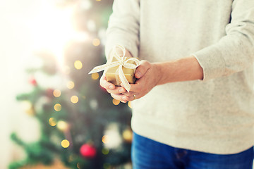 Image showing close up of man with christmas gift at home