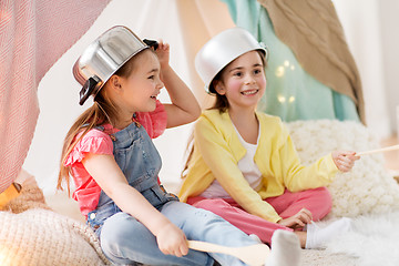 Image showing girls with kitchenware playing in tent at home