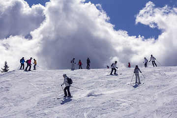 Image showing Skiers on mountainside  in the background light