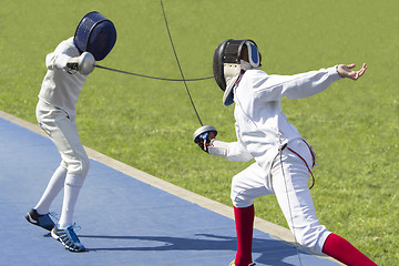 Image showing Two young man fencing athletes fight 