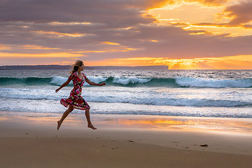 Image showing Female running along the beach in wet sand