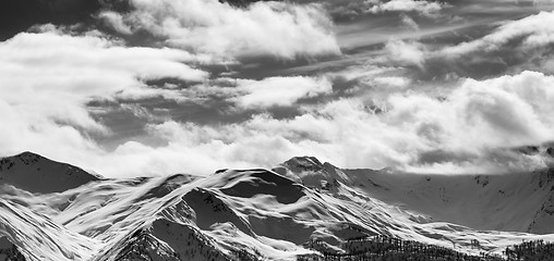 Image showing Black and white panoramic view on snow sunlight mountains and cl