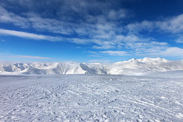 Image showing Ski slope, snow mountains and blue sky with clouds