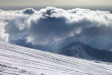 Image showing Ski slope for slalom and sunlight storm clouds