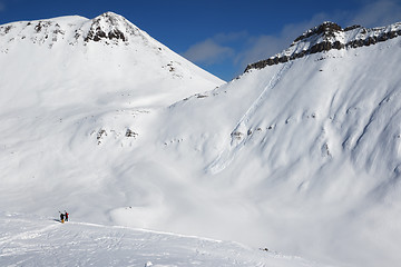 Image showing Two skiers and off-piste slope with traces of skis, snowboards a