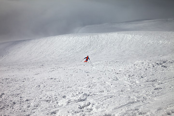 Image showing Skier downhill on freeride slope and overcast misty sky before b