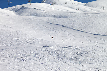 Image showing Skiers downhill on ski slope at nice sun day