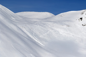 Image showing Snow off-piste slope with traces of skis, snowboards and avalanc