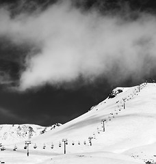 Image showing Black and white view on chair-lift and ski slope in sun day